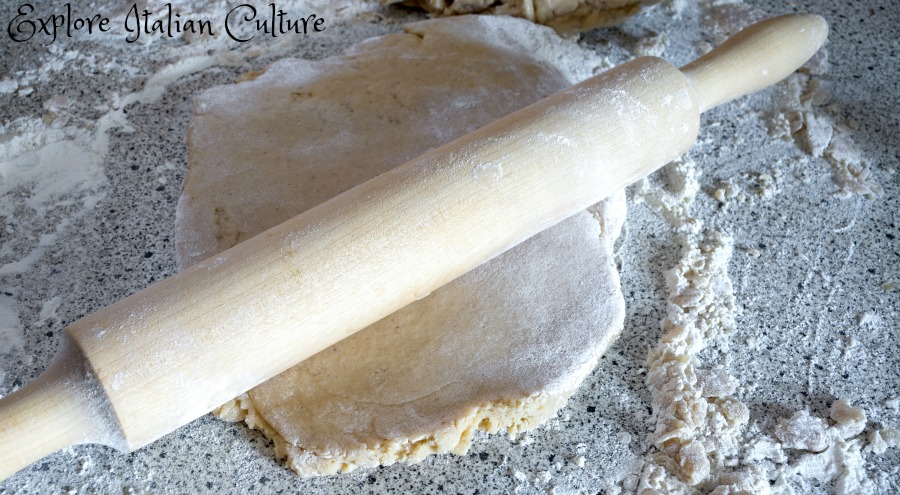 A rolling pin and home made pizza dough.